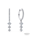An elegant pair of Lyra earrings, diamond-dusted hoops hung with three linked diamonds, casting a celestial spell wherever they go.